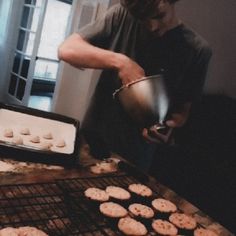 a man cooking cookies on top of a grill