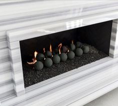 a white fireplace with rocks in it