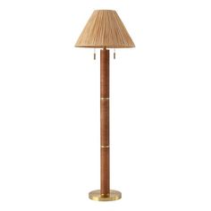 a floor lamp with a bamboo shade on it's top and gold trim around the base