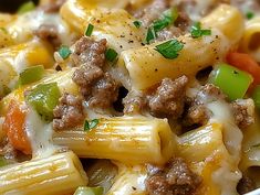 a bowl filled with pasta and meat covered in cheese