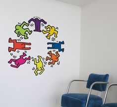 a blue chair sitting in front of a white wall with colorful stickers on it