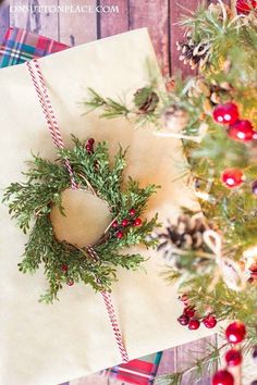 a present wrapped in brown paper and tied with twine on top of a table next to a christmas tree