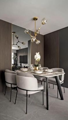 a dining room table with white chairs and a chandelier hanging from the ceiling