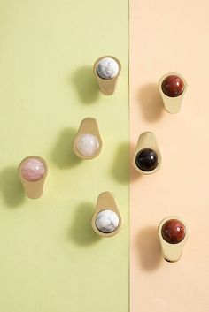 five small cups with different types of rocks in them on a pastel colored background