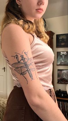 a woman with a dragonfly tattoo on her arm