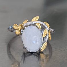 Fast free shipping Gemstone has been tested on one of the most accurate and reliable gemstone testing machines. Moonstone is genuine and is naturally mined. The flashy moonstone square earrings are brilliant. A cute moonstone sterling silver ring with 14k yellow gold overlay is perfect for the spring. It will remind you of white cherry blossoms in the spring. This moonstone ring has iridescent beautiful blue flashing hues. Rainbow Moonstone activates the Crown Chakra bringing In loving white hea Luxury Untreated Moonstone Ring For Anniversary, Luxury Fine Jewelry Moonstone Ring For Anniversary, Silver Moonstone Ring Fine Jewelry For Gift, White Oval Cabochon Moonstone Ring, White Cabochon Moonstone Ring Fine Jewelry, Fine Jewelry White Cabochon Moonstone Ring, Delicate White Moonstone Gemstone Ring, White Cabochon Moonstone Ring In Fine Jewelry Style, Handmade Silver Moonstone Ring Fine Jewelry