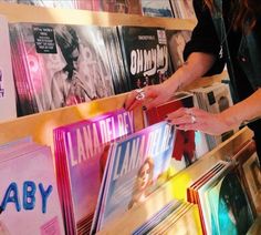 a woman standing in front of a shelf filled with records