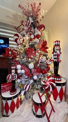 a christmas tree decorated in red and white with ornaments around it, including a nutcracker