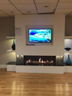 a flat screen tv mounted on the wall above a fireplace