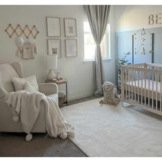 a baby's room with a crib, chair and pictures on the wall