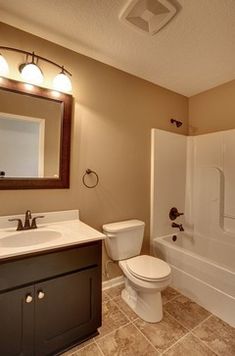 a bathroom with a sink, toilet and bathtub next to a shower stall in the corner