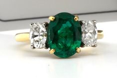 Gorgeous Natural Emerald and diamond ring having as the center One Oval 1.77ct Zambian emerald with clarity F1 ( minor) Graded by GIA set in 18kt gold with two oval diamonds also graded by GIA F color VS1 clarity and E color VS3 clarity which are set in Platinum settings. Finger size 6 . Pristine condition. Luxury Oval Three Stone Emerald Ring, Luxury Oval Emerald Ring With Three Stones, Oval Three-stone Emerald Ring For Formal Occasions, Oval Emerald Three-stone Diamond Ring, Oval Emerald Three Stone Diamond Ring, Oval Three Stone Emerald Ring For Formal Occasions, Oval Emerald Diamond Ring With Three Stones, Classic Oval Three-stone Emerald Ring, Classic Oval Emerald Ring With Three Stones