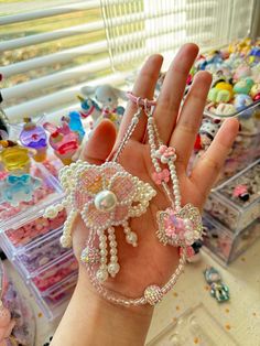 a hand is holding some beads and charms