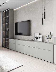 a living room with white furniture and a flat screen tv mounted on the wall above it