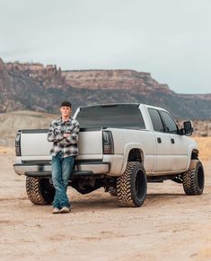 a man standing next to a truck in the desert