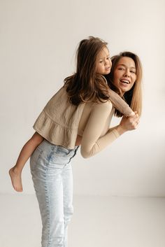 two young women are hugging each other while posing for a photo in front of a white background