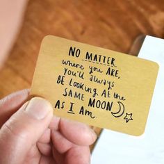 someone is holding up a card that says no matter where you are, you'll always be looking at the same moon as i am