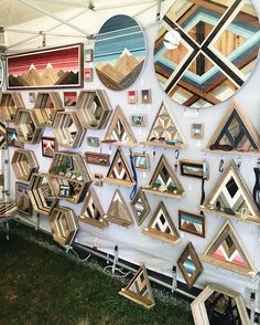 a wall covered in lots of different shaped and sized mirrors next to a white tent