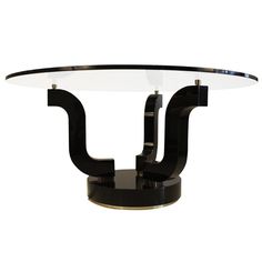 a black and white glass table with an unusual design on the top, against a white background