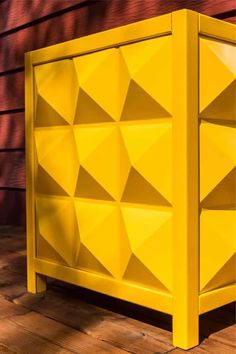 a yellow cabinet sitting on top of a wooden floor