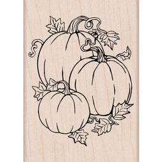 a rubber stamp with three pumpkins and leaves