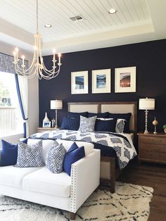 a bed room with a neatly made bed and a chandelier hanging from the ceiling