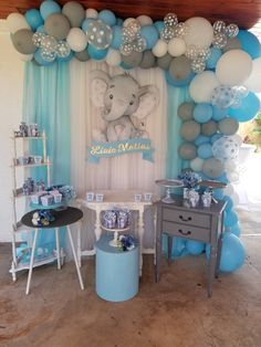 an elephant themed baby shower with balloons and decorations on the wall, table and stools