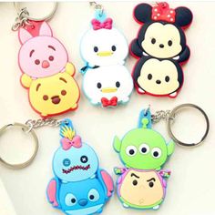 four cartoon key chains are shown on a white surface