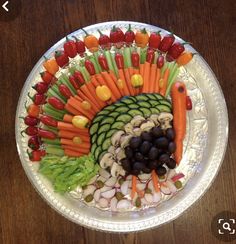 a platter with carrots, celery, and other vegetables on it