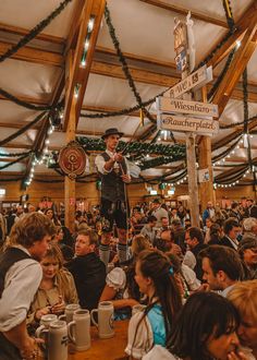 a man standing on top of a wooden pole in front of a large group of people