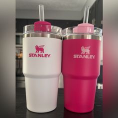 two pink and white tumblers sitting next to each other on top of a table