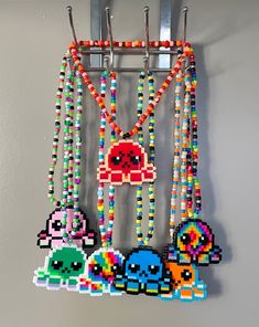 a bunch of beads hanging on a wall next to a metal rack with an object in the middle