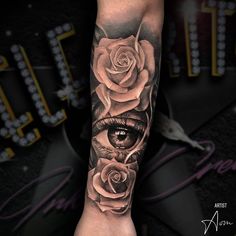 a woman's arm with a rose and eye tattoo on it