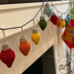 crocheted christmas ornaments hanging from a string on a fireplace mantel or mantle