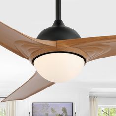 a ceiling fan in a living room with white walls and wood trim around the blades