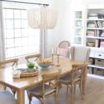 a dining room table and chairs in front of a book shelf with books on it