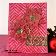 a close up of a card with flowers and glitters on it, next to some ornaments