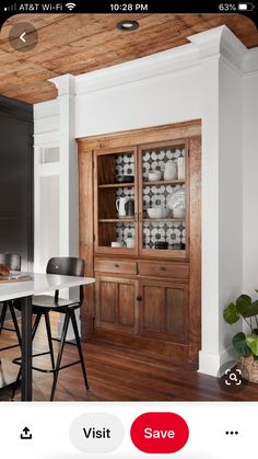 a dining room table with chairs and a china cabinet in the corner next to it