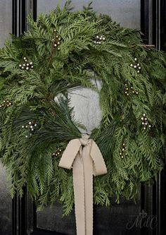 a wreath with a bow hanging on the front door