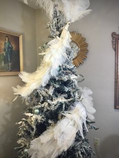 a white christmas tree with feathers on it