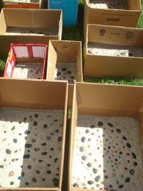 several cardboard boxes filled with different types of items on the ground in front of some grass