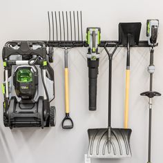 garden tools are hanging on the wall next to each other