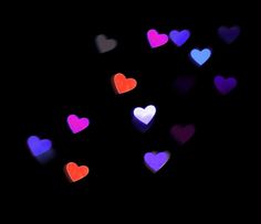 many different colored hearts floating in the air