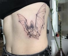 a woman with a bat tattoo on her stomach