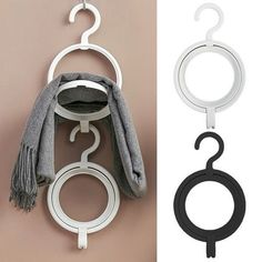 three hooks hang on the wall and one has a scarf hanging from it's hook