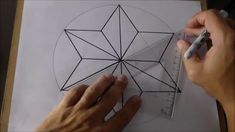 someone is drawing a geometric design on paper