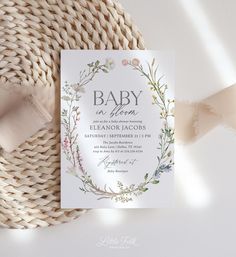 a baby is born announcement card on top of a woven piece of cloth next to a pink ribbon