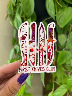 a person holding up a sticker that says first knives club in front of some plants