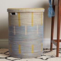 a blue and yellow basket sitting on top of a rug