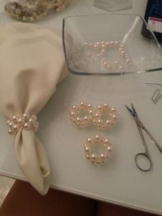 some pearls and scissors are sitting on a table with other items to be sewed